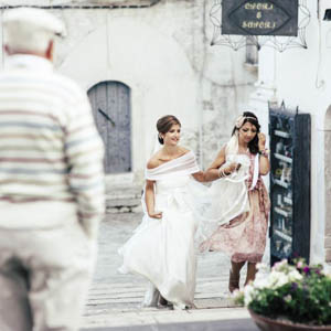 fotografia spontanea di matrimonio: la sposa cammina per le strade del paese a Monte Sant’ Angelo (FG)