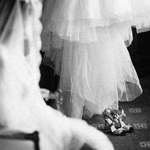hotel parco dei Principi, Roma: nella fotografia la sposa guarda le sue scarpe e l’ abito che sta per indossare per il matrimonio.