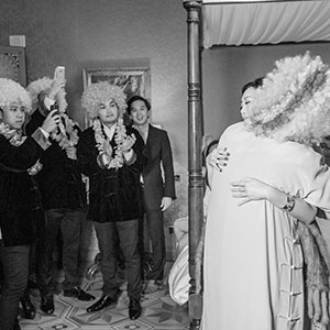 servizi fotografici spontanei di matrimonio, la sposa viene abbracciata dallo sposo con la parrucca da clown a villa Crespi ad Orta