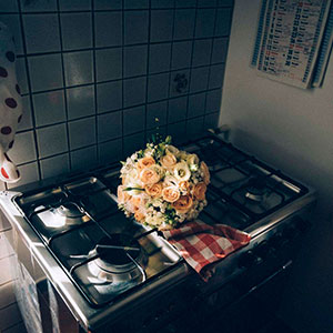 fotografia di matrimonio dissacrante: particolare del bouquet sui fornelli della cucina